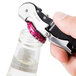 A hand using a Franmara Duo-Lever Waiter's Corkscrew with a black and silver Smart-Kut cutter to open a bottle.