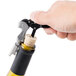 A hand using a Franmara Duo-Lever corkscrew to open a bottle of wine with a cork.