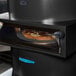 A pizza cooking in a TurboChef Fire electric countertop pizza oven.