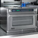 An Amana stainless steel commercial steamer microwave oven on a counter.