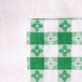 A white tablecloth with green and white checkered pattern on it.