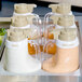 A Tablecraft tray of white plastic salad dressing containers with beige lettering.
