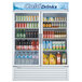A Turbo Air white glass door refrigerator full of drinks and beverages.