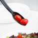 A Cambro black salad bar spoon with two cherry tomatoes on it.