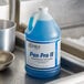 A blue bottle of Noble Chemical Pan Pro II liquid detergent on a metal sink.