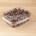 A Genpak plastic container filled with chocolate balls.