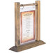 A Menu Solutions wood flip top table tent on a wooden table.