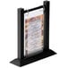 A Menu Solutions black wood flip top table tent with plastic sheet and rings holding a menu.
