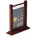 A Menu Solutions mahogany wood table tent with plastic sheets and rings holding a menu.