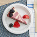 A slice of cheesecake with berries on an EcoChoice Compostable Bagasse plate.