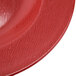 A close up of a textured red melamine bowl with a pattern.