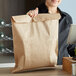 A woman holding a Duro brown merchandise bag.
