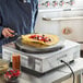 A chef using a Carnival King crepe maker to cook a crepe with fruit on it.