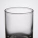A close up of a clear Libbey shot glass with a black rim.