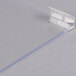 A clear plastic corner with a metal edge and a screw.