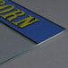 A blue glass panel with yellow writing that says "corn" on a table.