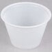 A Solo translucent polystyrene souffle cup on a gray surface.