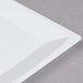 A close up of a white square WNA Comet Milan plastic salad plate with a curved edge.