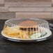 A Dart clear plastic dome plate cover with food in it.