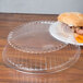A Dart clear plastic dome plate cover with a sandwich inside.
