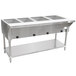 An Advance Tabco stainless steel hot food table with four pans on a counter.