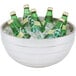 A Vollrath beehive metal bowl filled with green bottles of water in ice.