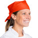 A woman wearing an orange chef bandana.