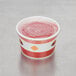 A Choice paper soup cup with a red plastic lid on top.