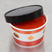 A white paper soup container with a black vented lid.