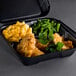 A black Genpak foam container with 3 compartments filled with chicken, macaroni, and green beans.
