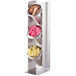 A stainless steel Cal-Mil vertical display with three metal cylinders filled with pink and yellow packets.