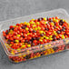 A plastic container of REESE'S candy pieces on a counter.