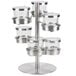 A stainless steel tiered rotating display stand with six glass jars with hinged lids inside.