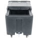 A black plastic Cambro mobile ice bin with a sliding lid on wheels.