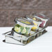 A Cal-Mil horizontal display tray with three stainless steel containers of fruit.