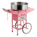 A pink cotton candy machine with a large stainless steel bowl and a wheeled cart.