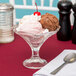 A Libbey glass bowl with ice cream, brownie, and a cherry on top.