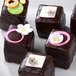 A close-up of chocolate squares cut with Ateco stainless steel pastry cutters, decorated with flowers.