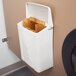 A white trash can with a Lavex sanitary napkin receptacle bag inside.