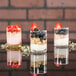 Three Libbey votive shot glasses filled with yogurt, berries, and granola.