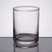 A Libbey clear glass votive shot glass on a table.