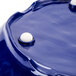 A cobalt blue melamine serving bowl with white buttons on a table.