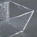 A clear square American Metalcraft Rain-Splashed Styrene bowl with a crack in it.