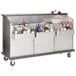 An Advance Tabco silver portable bar with bottles of alcohol and glasses inside.