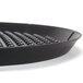 A black round pizza tray with a black handle.