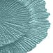 A close up of a turquoise glass charger plate with a large spiral reef design.
