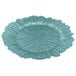 A close-up of a blue Charge It by Jay glass charger plate with a scalloped edge and a large flower design in the center.