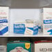 A white shelf with boxes of Medi-First Alcohol Prep Pads.