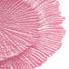 A close up of a pink Charge It by Jay glass charger plate with a large, wavy design.