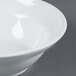 An American Metalcraft white stoneware bowl with a white rim on a gray surface.